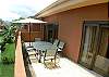 Second floor terrace with glass top table and comfortable chairs for six people and umbrella  at La Flor del Paraiso vacation rental home at La Flor beachfront gated community on the North side of Jaco beach Costa Rica