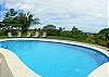 View of pool with lounge chairs and ocean view at Villa Oceana luxury vacation rental home in Esterillos, Costa Rica, half way between Jaco and Manuel Antonio.