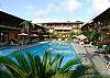 Large swimming pool with lanes and pool area with lounge chairs, and tables with umbrellas at MarArena beachfront vacation rental penthouse condo in Jaco, Costa Rica