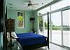 Master Bedroom with panoramic view of the ocean and the rainforest, King Size four poster bed, LCD TV, ensuite bathroom and balcony at Casa Infinito luxury vacation rental home at Valle Perdido in Playa Hermosa, Costa Rica