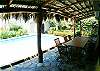 Pool and palm thatched terrace with table for 10 guests and gas grill at Casa Gris vacation rental house in Jaco, Costa Rica