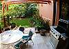 Covered terrace on ground floor with table and chairs and gas grill overlooking the garden at Casa Tortuga vacation rental house at Hermosa Palms in Hermosa beach, near Jaco