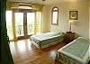 Second bedroom with Twin size beds, wood flooring, closet and ocean view, all with a green theme at the main house of Villa Oceana vacation rental in Esterillos Este, halfway between Jaco and Manuel Antonio, Costa Rica