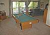 This room has it all, TV, pool table, sofa and love seat.