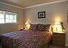 This bedroom has a queen size bed with lots of light and an attached bath.