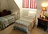 This bedroom is divided by a standing screen, one side offers two twin beds, while the other offers a king and childs crib, there is a small deck off of this bedroom.