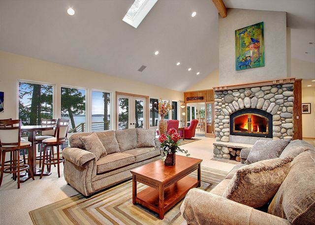 Large living room with a cozy wood-burning fireplace. Firewood not provided.