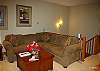 Top floor- lounge/loft with large corner sofa, stairs coming up from main floor.