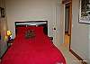Mid floor- 4th bedroom with queen bed, bathroom adjacent, large walk-in closet and window over looking groomed ski back.