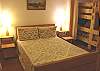 Bedroom with a Double bed and  curtain that separates it from the two Twin / Double Bunk beds with TV/VCR/DVD.