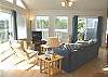 Upper level - Living room with hide-a-bed, TV/DVD and glass front pellet stove. Two sliders out to the wrap around deck.