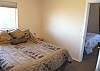 Bedroom with a Queen bed and door to third bedroom.