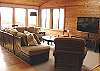 Second view of Upstairs living room with large screen TV/DVD, glass front wood stove and ocean views.