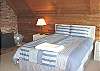 Upstairs loft style bedroom (right side) with Queen bed, wood stove, TV/VCR, CD player, full bathroom and beautiful ocean/mountain views.