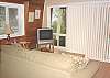 Living room with TV/DVD/VCR, gas wood stove and slider to deck.