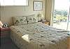 Bedroom with a Queen bed, slider out to front yard and ocean views.