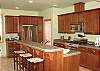 Large kitchen with granite counter tops, stainless steel appliances and breakfast bar for three.