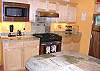 Second view of fully equipped kitchen with gas cook top and breakfast bar for 3.