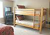 Second view - Upper level - Bedroom with a Queen bed and a Twin bunk bed with TV/DVD, ocean views and a door to balcony that over looks the backyard and stream.