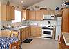 Upper level - Fully equipped kitchen with bar for 3 and dining table for 4 with one extra chair.