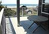 Upper level deck off living room with spectacular ocean views and a table with deck chairs.