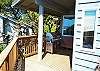Upper deck off the kitchen with ocean views, patio furniture and a gas BBQ.