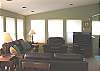 Second view - Upper level - Living room with flat screen TV/VCR/DVD, double sided fireplace and a door to the wrap around deck.