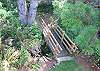 Second view - Large grassy backyard with small bridge that goes across a little stream.