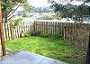 Second view of fenced backyard with hot tub.
