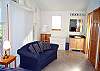 Second view - Upper level - Bedroom with Queen bed, TV/VCR/DVD, couch and slider out to upper deck with ocean views.