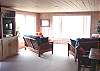 Second view - Upper level - Living room with two futons for additional sleeping, wood burning fireplace, flat screen TV/DVD, bench seat and spectacular ocean views out all windows.