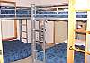 Lower level -  Bedroom with a Double Bunk bed and a Twin/Double Bunk bed.  Slider out to back patio with hot tub.