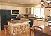 Upper level - Fully equipped kitchen with a breakfast bar for 4, slider to wrap around deck.