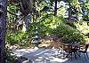 Large semi private back patio with hot tub and pation furniture.