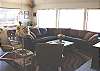 Middle (entry) level - Living room with large sectional, glass front wood stove and ocean views.