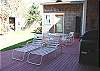 Second view - Back deck with patio furniture, hot tub, gas BBQ and bunk house with twin bunk bed.