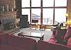 Third view - Upper level - Living room with large sectional, TV/VCR/DVD, wood stove insert, large picture windows with spectacular ocean views.