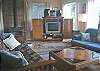 Upper level - Living room with futon for additional sleeping, TV/VCR/DVD and glass front wood stove.