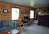 Third view - Lower level - Living room with TV/DVD, wood burning fireplace, hide a bed for additional sleeping and door out to large grassy backyard.