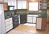 Upper level - Fully equipped kitchen with ocean views, wood stove and access out to hot tub.