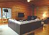 Upstairs living room with large screen TV/DVD, glass front wood stove and ocean views.