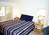 Upper level - Bedroom with Queen bed, TV/VCR/DVD, couch and slider out to upper deck with ocean views.