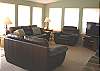 Upper level - Living room with flat screen TV/VCR/DVD, double sided fireplace and a door to the wrap around deck.