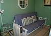 Downstairs bedroom with futon and door to backyard