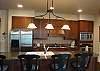 Four well-made barstools on a swivel compliment the spacious kitchen with granite counter tops and stainless steel appliances