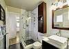 Recently renovated bathroom boasts a glass shower enclosure and a single vanity with ample storage space.