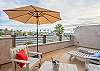 UNIT B (3Bdrm):  An upper patio with glimpses of the ocean in the distance. Hosted with comfortable lounge chairs and additional seating, this elevated outdoor space invites relaxation and enjoyment of the stunning coastal scenery. 
