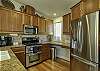 Stainless steel kitchen appliances.  Kitchen area extends into great room.