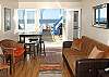 3rd floor living area with "Click Clack" bed and TV/DVD. Door opens out to balcony and roof top deck. Opposite end of room is a private bedroom with a queen murphy bed with bay view.