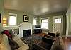 The living room features comfortable seating, a cozy gas fireplace, and a large 32" LCD TV with digital cable and DVD player.